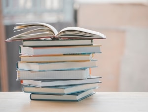 Stack of books with an open book on top