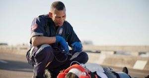 EMS professional speaking with a stabilized car crash victim
